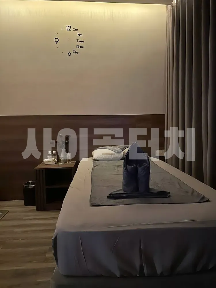 벽시계와 깔끔한 마사지 침대