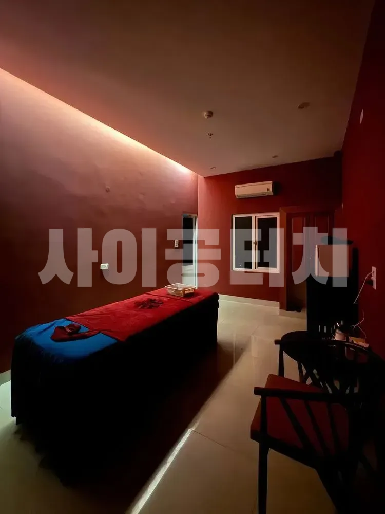 붉은 조명 아래의 마사지 베드