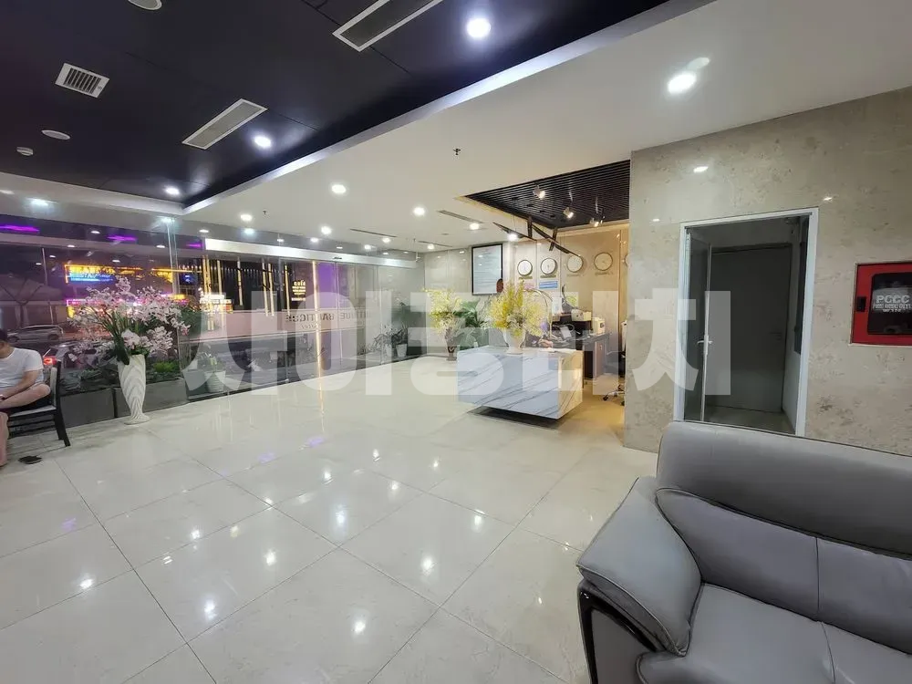 흰색 타일 바닥과 안내 데스크가 있는 로비