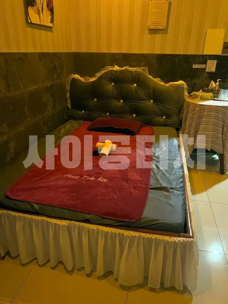 녹색 헤드보드와 빨간 수건의 마사지 침대