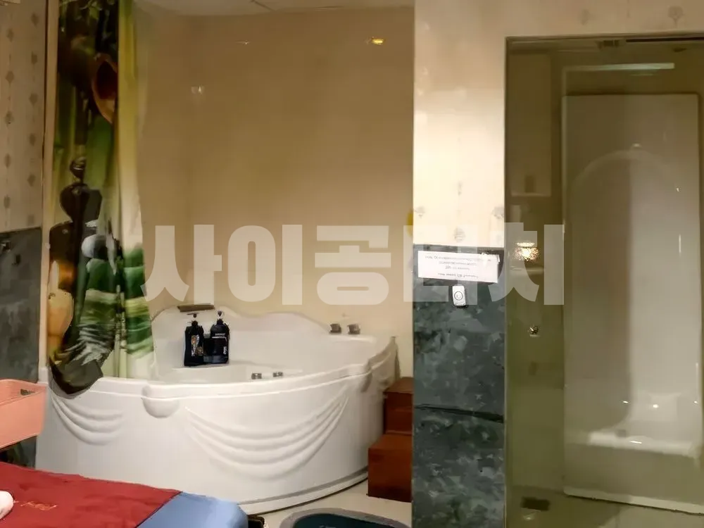 흰색 자쿠지 욕조와 유리 샤워 부스가 있는 욕실