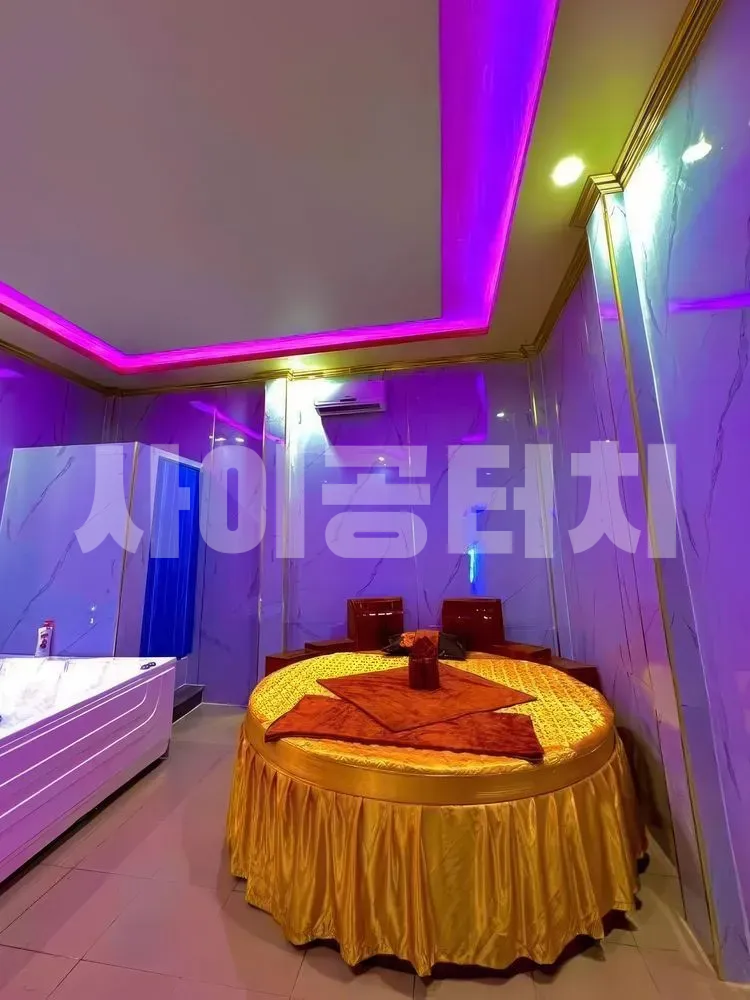 보라색 조명과 대리석 벽의 마사지 룸