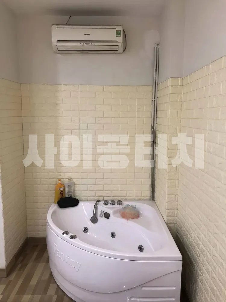 벽돌 무늬 벽 앞에 놓인 코너 욕조