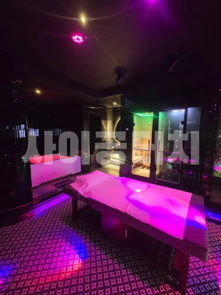 핑크빛 조명이 돋보이는 마사지 룸